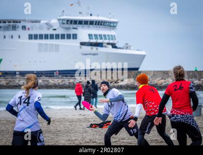 Rostock, Germania. 06th maggio, 2023. Al quinto Campionato tedesco Mixed Beach in beach frisbee, le squadre di Rotpot Braunschweig (bianco) e Funatics Hannover giocano l'una contro l'altra sulla spiaggia del Mar Baltico di Warnemünde. Nel concorso, cinque giocatori per squadra cercano di ottenere il frisbee nella zona finale della metà dell'avversario. Un totale di 24 squadre con 200 giocatori provenienti da tutta la Germania giocano per il campionato tedesco. Credit: Jens Büttner/dpa/Alamy Live News Foto Stock