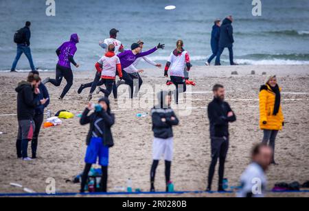 Rostock, Germania. 06th maggio, 2023. Al quinto campionato tedesco di spiaggia mista in beach frisbee, squadre di Goldfingers Potsdam (viola) e Funatics Hannover giocano l'una contro l'altra sulla spiaggia del Mar Baltico a Warnemünde. Nelle competizioni, cinque giocatori per squadra cercano di ottenere il frisbee nella zona finale della metà dell'avversario. Un totale di 24 squadre con 200 giocatori provenienti da tutta la Germania giocano per il campionato tedesco. Credit: Jens Büttner/dpa/Alamy Live News Foto Stock