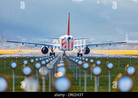 Aeromobili sul asfalto, illuminazione del campo aereo, easyJet, Airbus A320-200, aeroporto di Kranebitten, Innsbruck, Tirolo, Austria Foto Stock