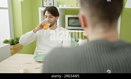 Due uomini sorridono fiduciosi di fare colazione nella sala da pranzo Foto Stock