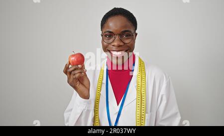 Donna afroamericana dietista sorridente sicuro tenendo la mela sopra lo sfondo bianco isolato Foto Stock