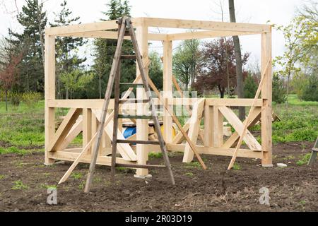 La cornice di un gazebo in legno. Costruzione di un gazebo in un parco cittadino Foto Stock