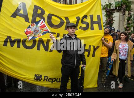 Londra, Regno Unito. 06th maggio, 2023. Un protesta contro la monarchia si trova di fronte a un grande banner che recita "abolire la monarchia" nel centro di Londra il 6 maggio 2023, quando l'incoronazione di Re Carlo III ebbe luogo a breve distanza. In precedenza, il capo del gruppo di campagna anti-monarchico Repubblica e alcuni attivisti sono stati arrestati dalla polizia a Trafalgar Square. E 'stata la prima incoronazione di un nuovo monarca a Londra, Regno Unito, per 70 anni e, nonostante la pioggia costante, molte migliaia di persone sono scesi nella capitale per godersi le celebrazioni. Credit: Andy Soloman/Alamy Live News Foto Stock