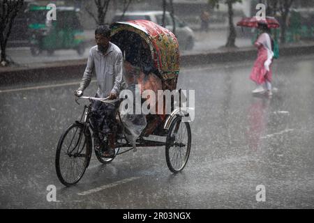 Dhaka, Bangladesh. 06th maggio, 2023. Un estrattore di risciò visto cavalcare lungo la strada in una giornata piovosa. Il pesante versamento di monsoni ha reso il viaggio lento e pericoloso. (Foto di Sazzad Hossain/SOPA Images/Sipa USA) Credit: Sipa USA/Alamy Live News Foto Stock