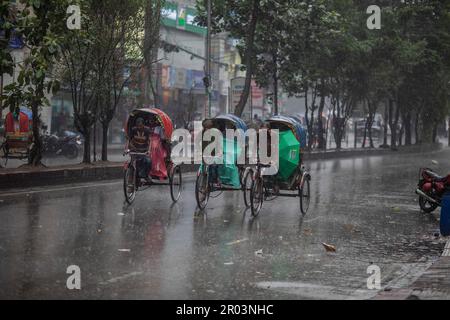 Dhaka, Bangladesh. 06th maggio, 2023. I tiratori di risciò hanno visto andare in strada in una giornata di pioggia. Il pesante versamento di monsoni ha reso il viaggio lento e pericoloso. (Foto di Sazzad Hossain/SOPA Images/Sipa USA) Credit: Sipa USA/Alamy Live News Foto Stock