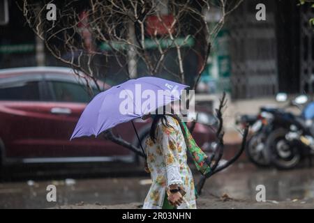 Dhaka, Bangladesh. 06th maggio, 2023. Una donna tiene un ombrello mentre cammina lungo la strada in una giornata piovosa. Il pesante versamento di monsoni ha reso il viaggio lento e pericoloso. (Foto di Sazzad Hossain/SOPA Images/Sipa USA) Credit: Sipa USA/Alamy Live News Foto Stock