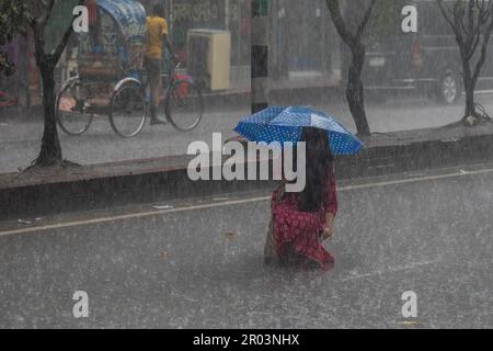 Dhaka, Bangladesh. 06th maggio, 2023. Una donna tiene un ombrello mentre cammina lungo la strada in una giornata piovosa. Il pesante versamento di monsoni ha reso il viaggio lento e pericoloso. (Foto di Sazzad Hossain/SOPA Images/Sipa USA) Credit: Sipa USA/Alamy Live News Foto Stock