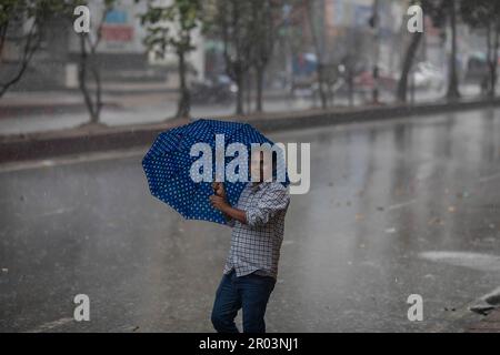 Dhaka, Bangladesh. 06th maggio, 2023. Un uomo tiene un ombrello mentre cammina lungo la strada in una giornata piovosa. Il pesante versamento di monsoni ha reso il viaggio lento e pericoloso. (Foto di Sazzad Hossain/SOPA Images/Sipa USA) Credit: Sipa USA/Alamy Live News Foto Stock