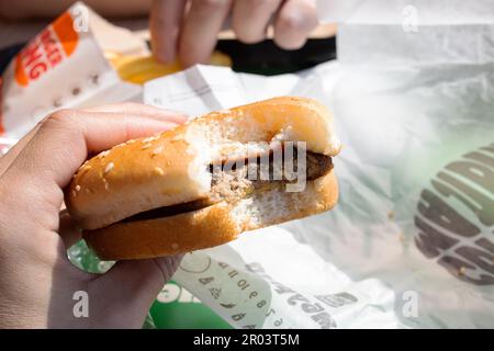 Minsk, Bielorussia - 20 aprile 2023: Cheeseburger in mano al Burger King primo piano Foto Stock