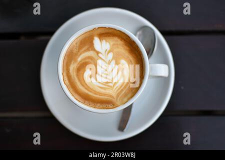 tazza di cappuccino con disegno floreale Foto Stock