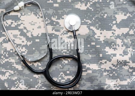 Lo stetoscopio si trova sull'uniforme di un soldato statunitense. Il concetto di assistenza sanitaria, assicurazione militare, assistenza statale. Vista dall'alto. Supporti misti Foto Stock