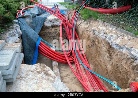 installazione di infrastrutture per cavi elettrici sotterranei. Cantiere con molti cavi di comunicazione protetti in tubi. elettrico e alta-spe Foto Stock