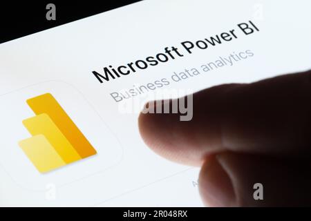 App Microsoft Power BI visualizzata in App Store sullo schermo dell'ipad e con un dito sfocato che punta verso di essa. Analisi dei dati aziendali. Stafford, Regno Unito, M. Foto Stock