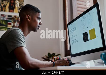 Nel profondo della zona creativa. un giovane uomo d'affari che usa un computer in un ufficio moderno. Foto Stock