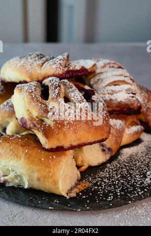 Viziatevi con la dolcezza di queste deliziose focaccine di mirtillo servite su un piatto rustico. Queste soffici e soffici ciambelle sono riempite di succosa mirtilli Foto Stock