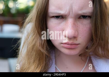 Arrabbiato furious ragazza giovane adolescente guardando macchina fotografica e sopracciglia solcata Bad mood adolescenza Foto Stock