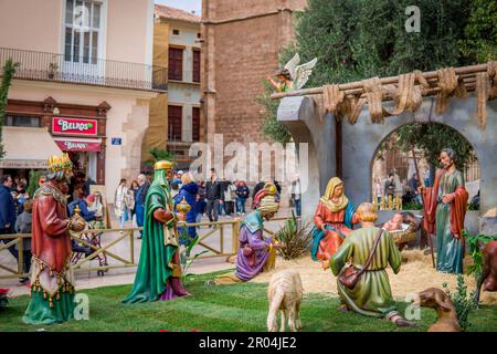 Foto delle figure della presepe di Natale in Plaza de la Reina raffigurante la nascita di Gesù Cristo con le persone che camminano sullo sfondo Foto Stock