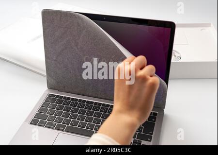 Fuji-shi, Shizuoka-ken, Giappone - 11 marzo 2022: Rimozione della carta protettiva dallo schermo del MacBook Air M1. Foto Stock