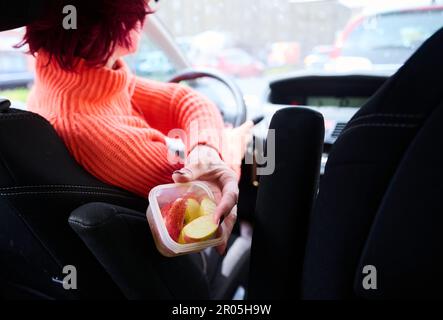 Berlino, Germania. 04th maggio, 2023. Una madre consegna un pezzo di mela a un bambino mentre si parcheggia fuori. (A dpa ''moralmente sul gancio' - 100 anni della festa della mamma in Germania'). Credit: Annette Riedl/dpa/Alamy Live News Foto Stock