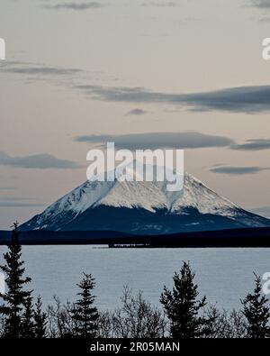 Splendido paesaggio invernale vicino a Whitehorse nel territorio dello Yukon, con enormi montagne innevate sulla strada per Atlin, British Columbia. Foto Stock