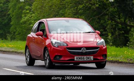 Stony Stratford, Bucks, Regno Unito - Aprile 30th 2023. 2016 rosso VAUXHALL CORSA viaggiando su una strada di campagna inglese Foto Stock