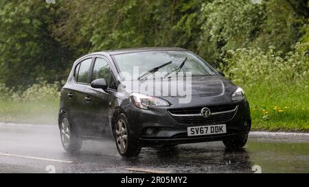 Stony Stratford, Bucks, Regno Unito - Maggio 6th 2023. 2017 VAUXHALL CORSA guidare sotto la pioggia su una strada bagnata Foto Stock