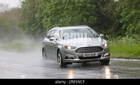 Stony Stratford, Bucks, Regno Unito - Maggio 6th 2023. 2017 FORD MONDEO TITANIO guida sotto la pioggia su una strada bagnata Foto Stock