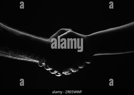 Stretta di mano tra i due partner, accordo. Salvataggio mani maschili. Stretta di mano amichevole, saluto degli amici, amicizia. Salvataggio, aiuto gestuale o mani Foto Stock