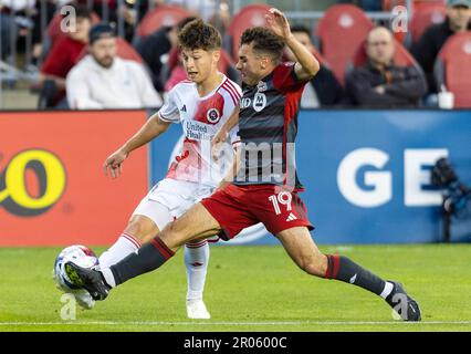 Toronto, Canada. 6th maggio, 2023. Esmir Bajraktarevic (L) del New England Revolution vies con Kobe Franklin del Toronto FC durante la loro partita di calcio della Major League 2023 (MLS) al BMO Field di Toronto, Canada, 6 maggio 2023. Credit: Zou Zheng/Xinhua/Alamy Live News Foto Stock