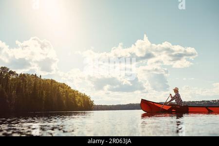 Si mette in acqua ogni volta che può. una giovane donna attraente che trascorre una giornata in kayak sul lago. Foto Stock