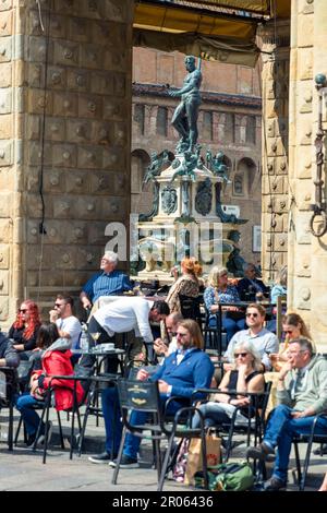 Menschen im Cafe auf der Piazza Nettuno, im Hintergrund der Neptunbrunnen in der historischen Altstadt, Bologna, Emilia - Romagna, Italien Foto Stock