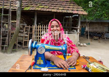 Bangladesh – 19 maggio 2019: Una donna di un villaggio di mezza età si siede nel cortile per cucire la sua famiglia a Jibannagar Upazila, nel distretto di Chuadanga. Foto Stock