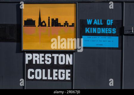 'Prendere un cappotto lasciare un cappotto' e donare abbigliamento invernale a Preston College, Lancashire UK. 6 maggio 2023. 'Lasciate un cappotto' sul muro della gentilezza. Negozi e negozi nella strada principale del centro di Preston il giorno dell'incoronazione del Re. Foto Stock