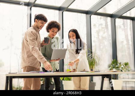 Team di colleghi che utilizzano il laptop per lavorare in squadra in ufficio Foto Stock