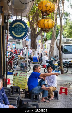 Uomini vietnamiti seduti al bar Sidewalk per colazione, ho Chi Minh City, Vietnam Foto Stock