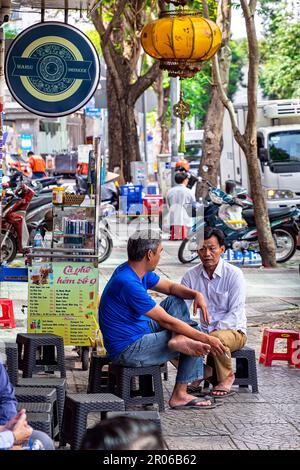 Uomini vietnamiti seduti al bar Sidewalk per colazione, ho Chi Minh City, Vietnam Foto Stock