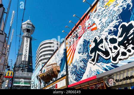 Ristoranti e negozi nel quartiere di Shinsekai insieme alla Torre Tsutenkaku (Osaka, Giappone) Foto Stock