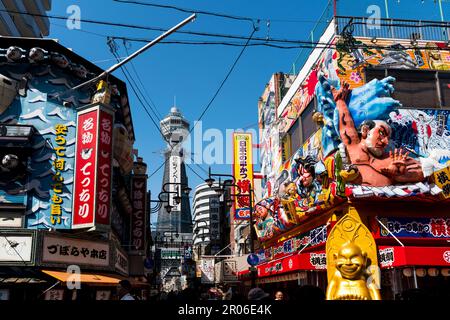 Ristoranti e negozi nel quartiere di Shinsekai insieme alla Torre Tsutenkaku (Osaka/Giappone) Foto Stock