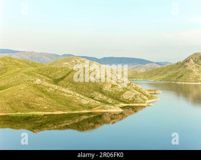 Montagne bagnate dal mare nel calmo clima estivo. Il bacino idrico di Bukhtarma si trova nella regione orientale del Kazakistan. Foto Stock