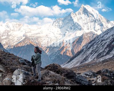 Donna escursionista backpacker a Annapurna base e gamma Machhapuchhre in background. Foto Stock