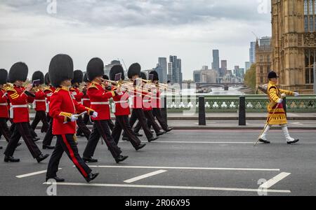 Mentre marciano in costume cerimoniale attraverso il Westminster Bridge, una band appartenente alla Bristish Army Guards Division suona musica, guidata da una band l Foto Stock