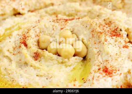 Hummus di ceci con olio d'oliva e paprika affumicata da vicino. Cibo vegano sano. Foto Stock