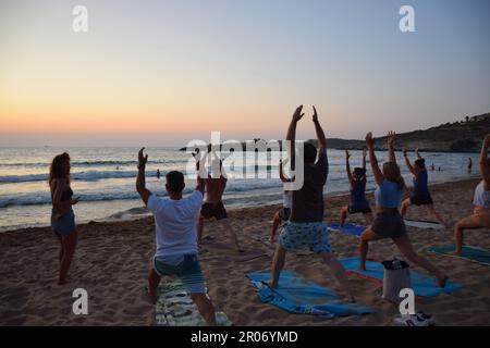 yoga sulla spiaggia in Grecia, ritiro tYoga, lezione di yoga di gruppo sulla spiaggia Foto Stock