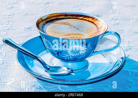 Tè al latte o caffè con latte in tazza con motivo blu d'annata Foto Stock