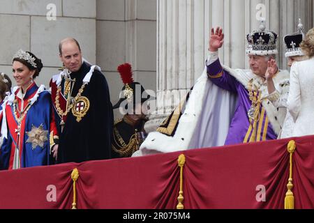 Il Principe di Galles guarda come re Carlo III, che indossa la Corona Imperiale di Stato, e la Regina Camilla, che indossa una versione modificata della Corona della Regina Maria, si muovono sul balcone di Buckingham Palace, Londra, dopo l'incoronazione. Data immagine: Sabato 6 maggio 2023. Foto Stock