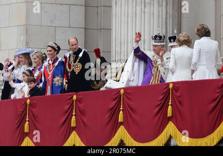 Il Principe di Galles guarda come re Carlo III, che indossa la Corona Imperiale di Stato, e la Regina Camilla, che indossa una versione modificata della Corona della Regina Maria, si muovono sul balcone di Buckingham Palace, Londra, dopo l'incoronazione. Data immagine: Sabato 6 maggio 2023. Foto Stock