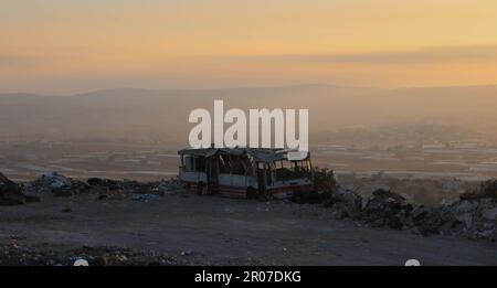 Arrugginito vecchio abbandonato autobus rosso relitto nel paesaggio della Palestina Foto Stock