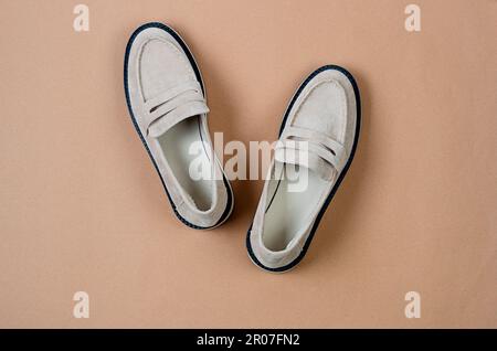 Paio di eleganti scarpe in pelle scamosciata beige da donna su sfondo beige. Moda donna Spring. Foto Stock