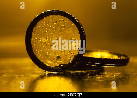 l'obiettivo filtra con gocce d'acqua riflesse nello specchio Foto Stock