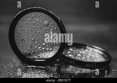 l'obiettivo filtra con gocce d'acqua riflesse nello specchio Foto Stock